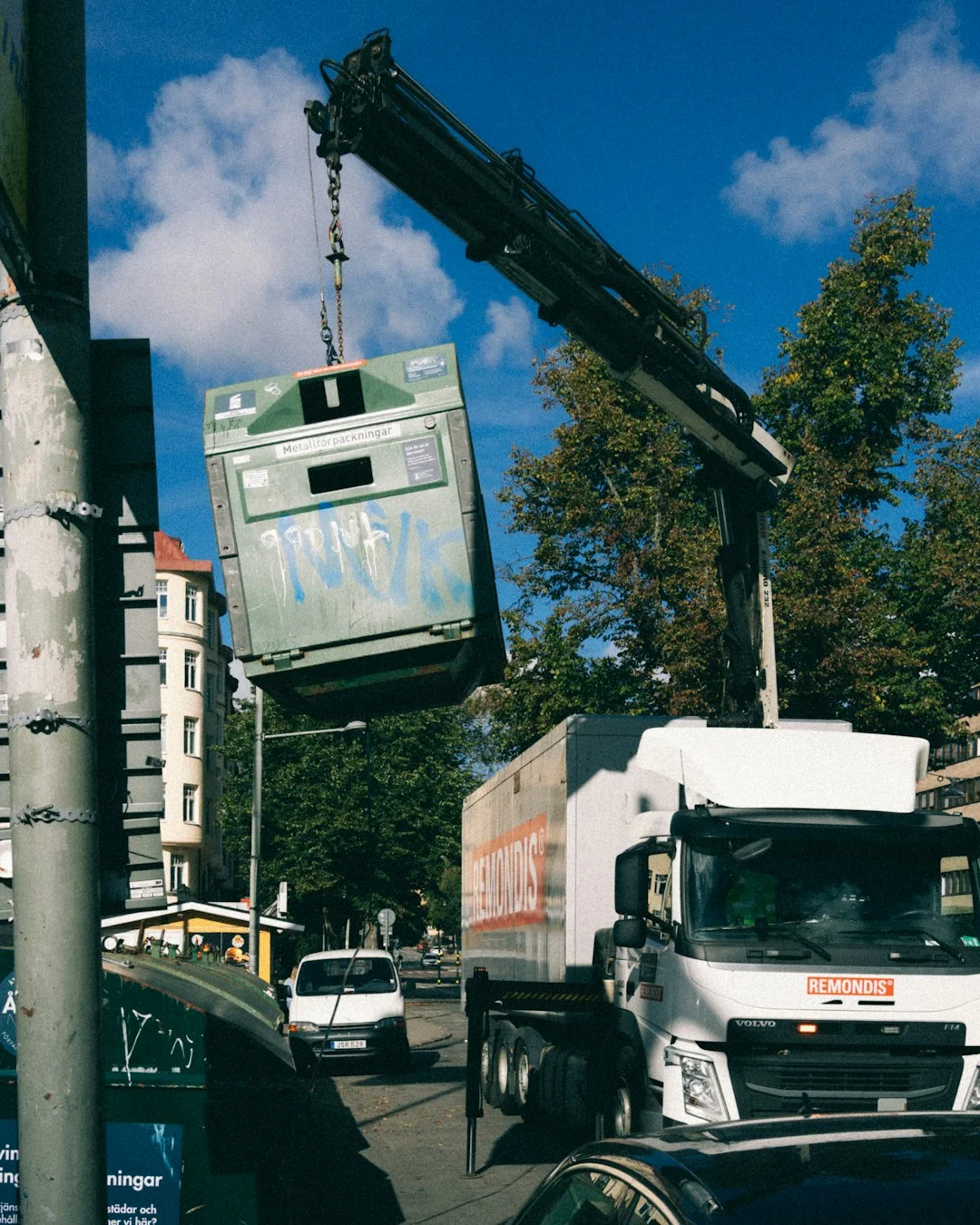Canapé recouvert d’un drap et lampadaire au sol, avec des cartons emballés dans une pièce lumineuse et spacieuse d’une maison contemporaine neuve